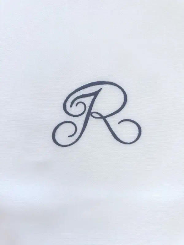 White pillowcase embroidered with an R monogram for Reid's Palace